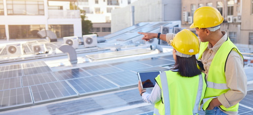 Workers on sustainable energy project on rooftop of building