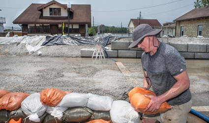 Person building sandbag barrier